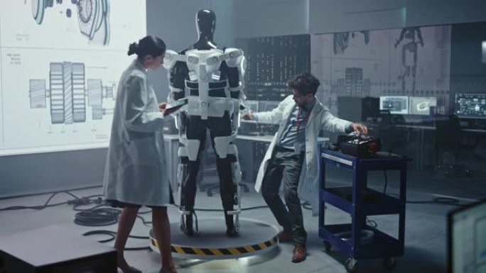 在机器人技术开发实验室: 首席女工程师和顶级男科学家在仿生外骨骼原型上工作。设计动力外衣以帮助残疾人