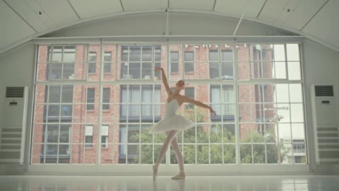 优雅的女芭蕾舞演员独自在工作室跳舞和练习舞蹈。一位优雅，严肃和无忧无虑的芭蕾舞演员在学校或班级为表演