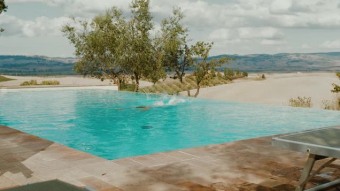 超级SLO MO女人跳入托斯卡纳度假别墅的游泳池