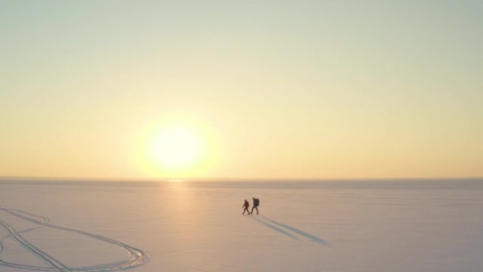 穿过雪场的两个旅行者