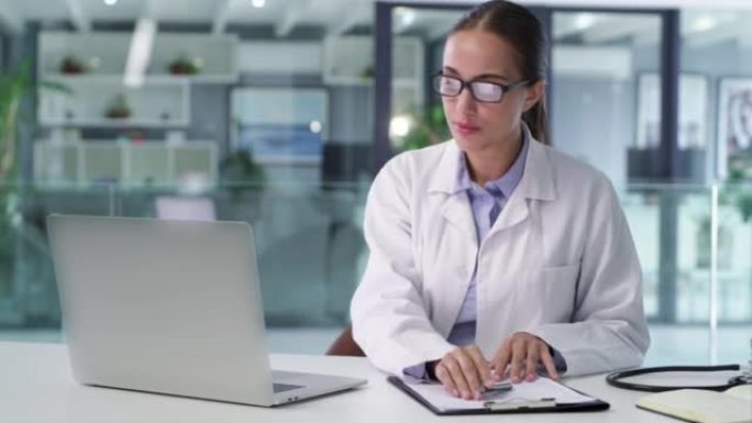 一位自信的医生在医疗办公室工作笔记本电脑。值得信赖的女医生和专业的医疗保健从业者在医院进行研究和浏览