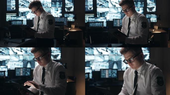 摄像头会拍摄一名独自在办公室里上夜班用平板电脑工作的保安人员的全貌，然后转向脸部特写。