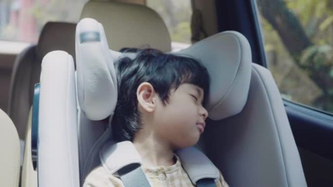 儿童安全汽车座椅中的亚洲男孩。