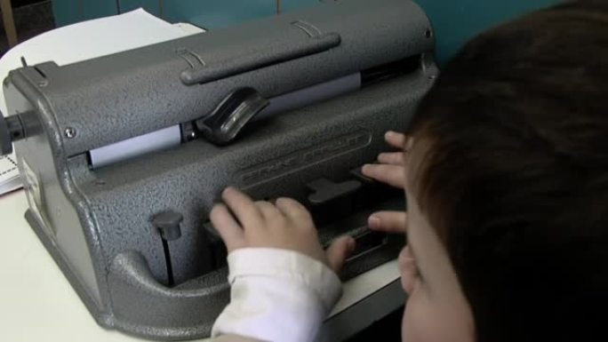 在阿根廷的一所盲人和视障儿童学校，盲人在课堂上使用盲文打字机。特写。