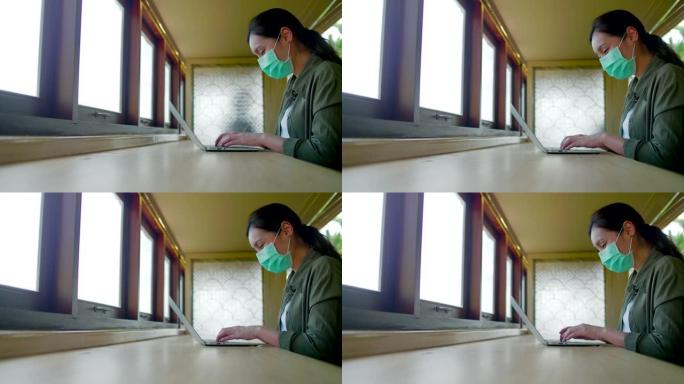 戴着医用口罩的女人在咖啡馆社交距离时工作