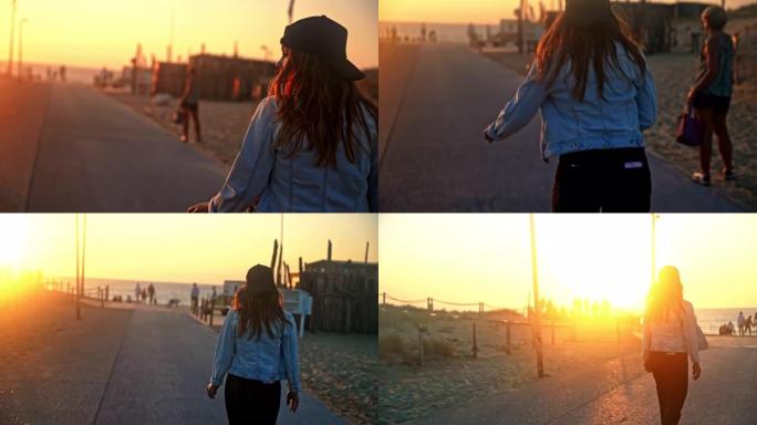 日落时，棕色头发的特写年轻女子在木板路上的滑板上滑冰，后视图