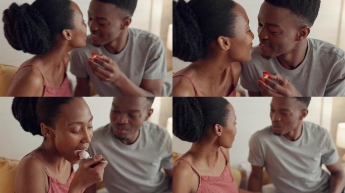 情侣接吻，吃早餐，对营养食品感到满意，早上为水果微笑，在家庆祝爱情。非洲男女在卧室里用健康饮食接吻