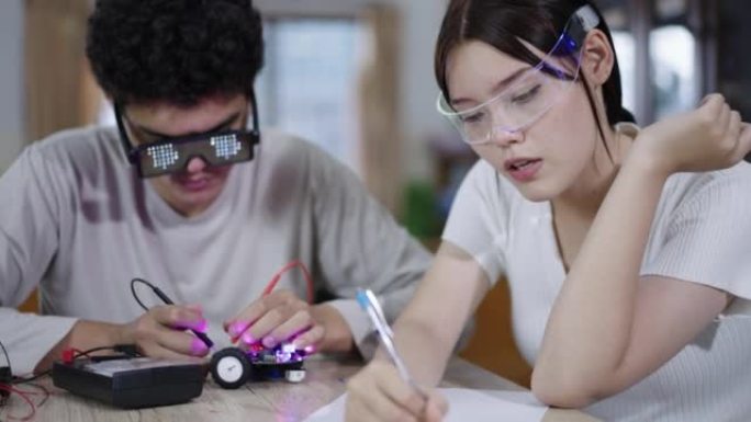 青少年在学校学习学习和修理机器人