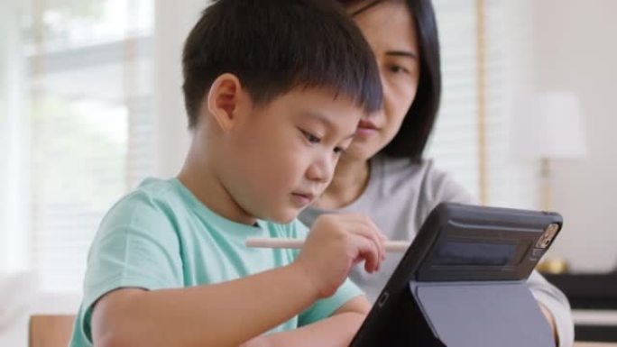 孩子和妈妈享受周末活动在家一起在线玩游戏。