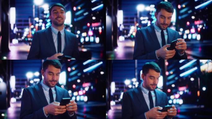一个穿着时髦西装的英俊男子的肖像在夜晚霓虹灯的现代城市街道上行走。有吸引力的男性使用智能手机，检查社