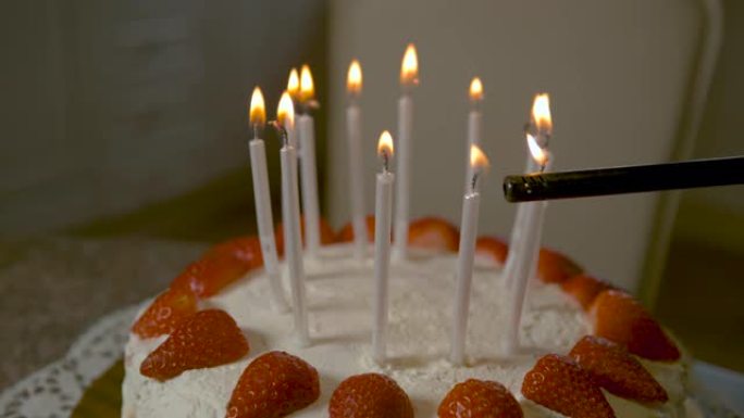 宏观: 无法识别的人使用打火机点亮生日蛋糕蜡烛。