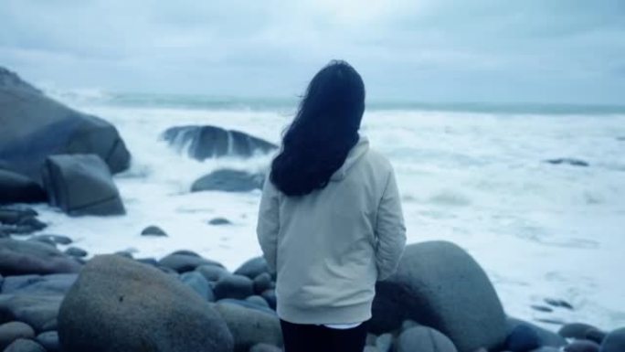 一个女人在云日独自看着海浪