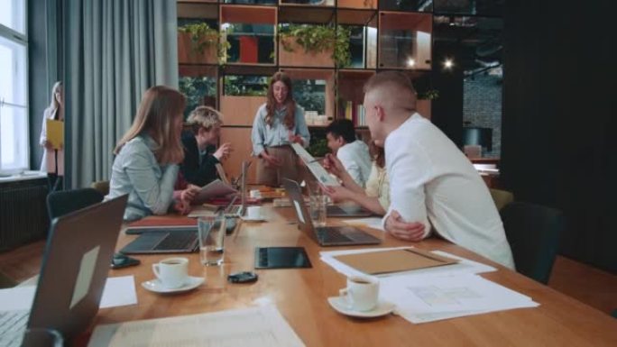 商务会议小组的快乐兴奋的同事集思广益，在时尚的办公室工作场所餐桌上一起工作。