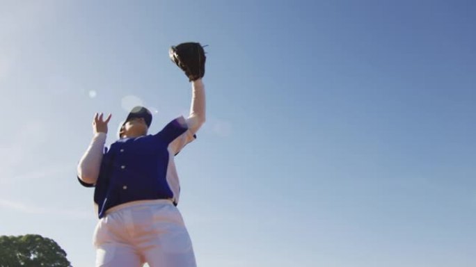 混血女棒球野手在阳光明媚的棒球场上接球和丢球