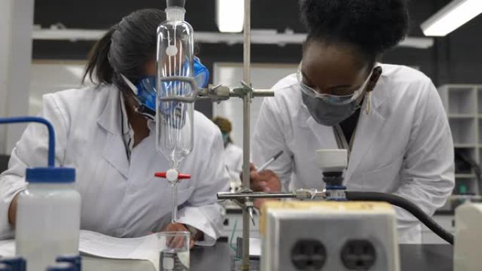 在实验室工作的多种族学生戴着口罩