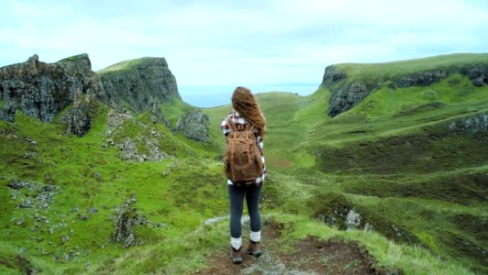 4k视频片段，一名妇女在远足时在山上拍照
