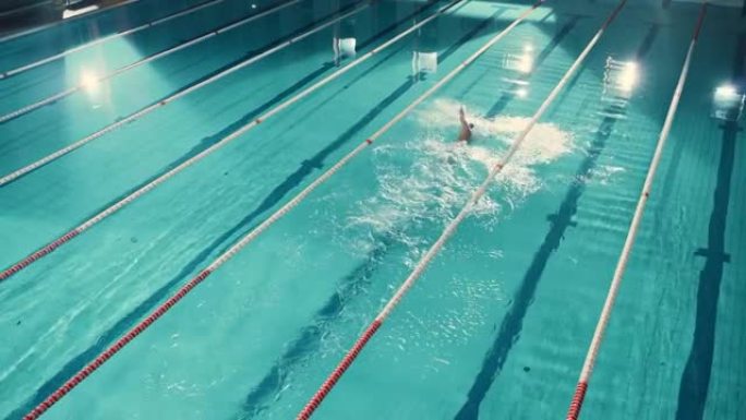 空中俯视图男游泳者在游泳池中，以创纪录的速度跑圈。专业运动员训练比赛，赢得世界冠军自由泳。电影宽固定