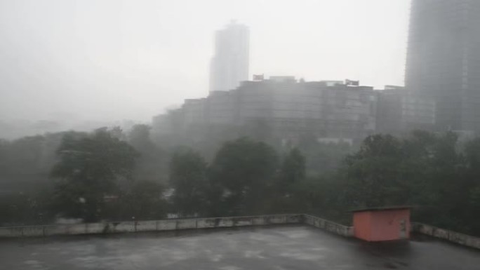 恶劣天气下雨天，高角度视角停车场屋顶淹没树木和办公楼背景