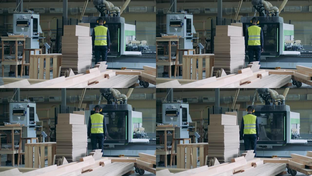 男人在工厂看用木材工作的工业机器。