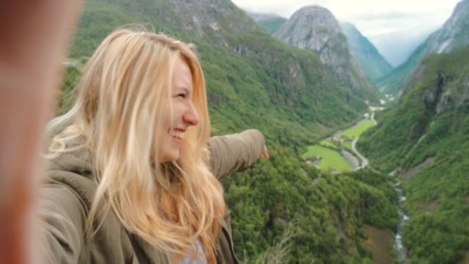 4k视频片段，一位迷人的年轻女子在Naeroydalen山谷远足期间录制视频
