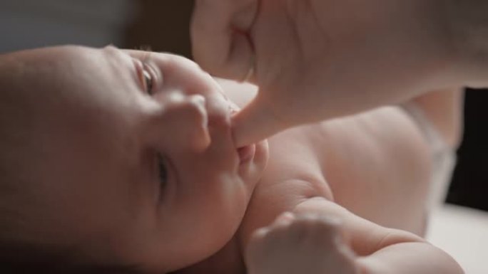 SLO MO婴儿男孩吮吸母亲的小指