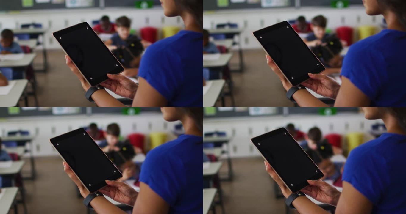 混血教师的中部使用平板电脑，屏幕上有复制空间，背景中的儿童