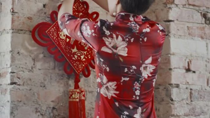 亚洲妇女悬挂中国新年装饰