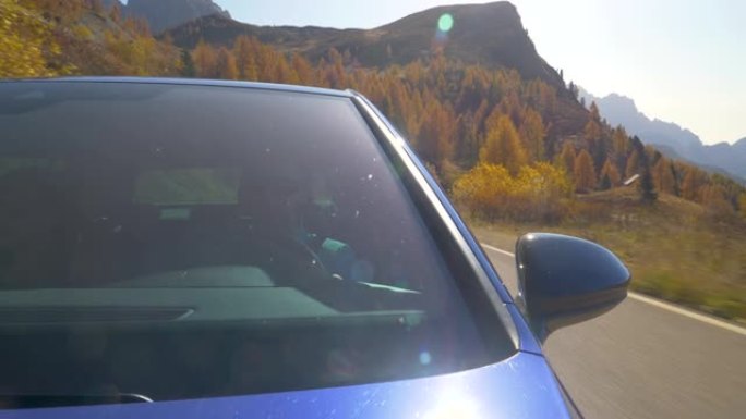 特写: 男子开车送女友沿着多洛米蒂山脉的风景秀丽的山路。