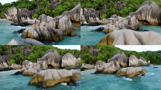 在塞舌尔拉迪格壮观的Anse Source d'Argent海滩上，穿着游泳衣站在花岗岩巨石上的鸟瞰