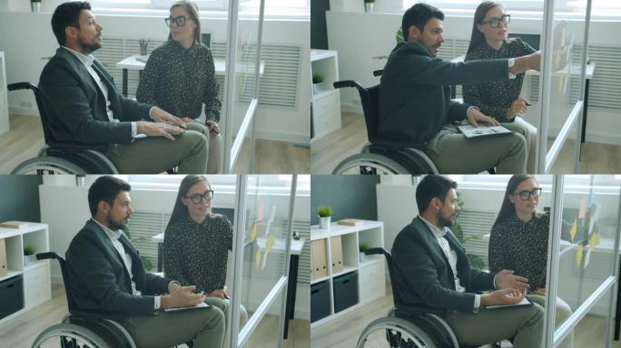 同事残疾男人和健康的女人在办公室讨论便签信息