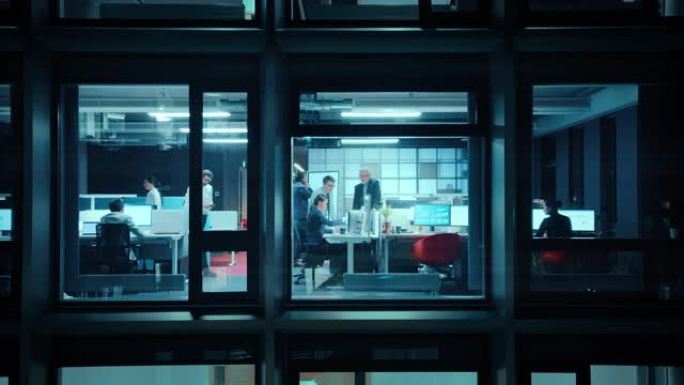 窗外的镜头: 在办公室工作的商人和女商人。经理和专家在晚上做金融业务。员工在计算机上工作并委派任务。