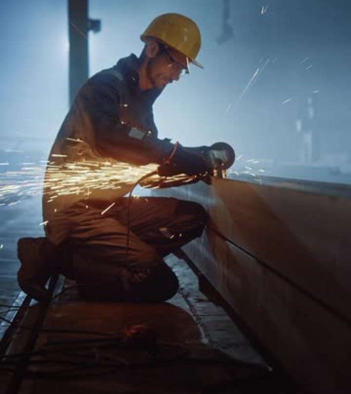 重工业工程工厂内部与工业工人使用角磨机和切割金属管。安全和安全帽制造金属结构的承包商。垂直屏幕