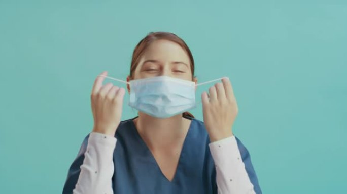 4k视频片段，一名年轻护士独自站在诊所并摘下口罩