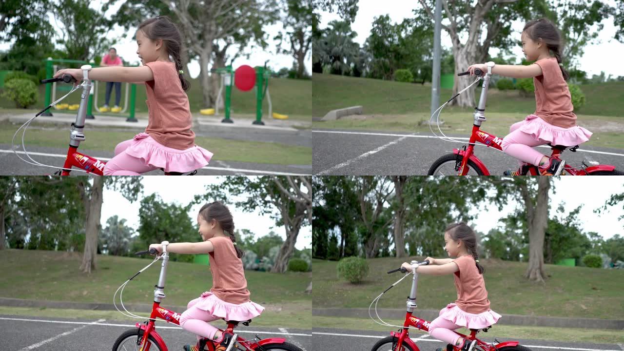 可爱的小女孩在公园里骑自行车