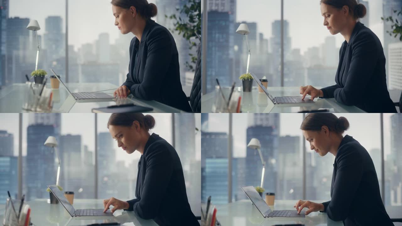 成功的女商人穿着时髦的西装在笔记本电脑上工作，看着窗外的大城市。自信的女CEO分析金融项目。工作计划