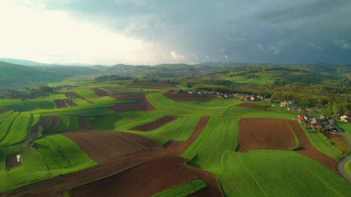 带有草地，田野和小村庄的丘陵乡村的空中壮丽景色