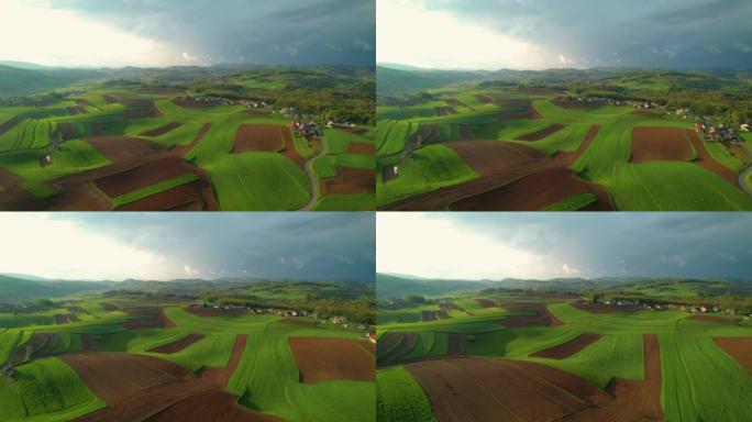 带有草地，田野和小村庄的丘陵乡村的空中壮丽景色