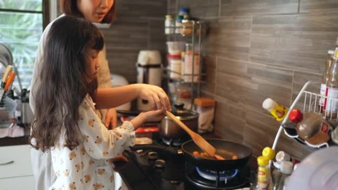 母亲教女儿在厨房里做早餐