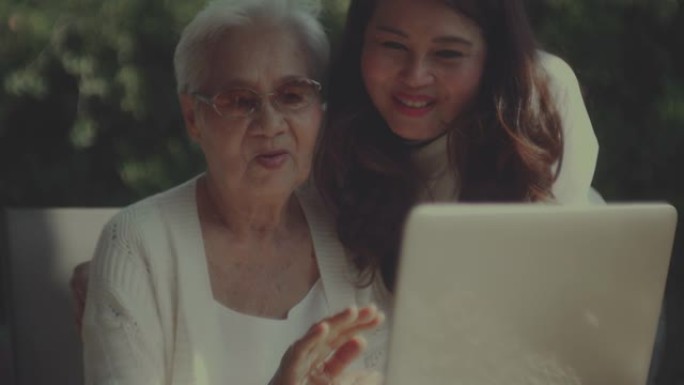 亚洲妇女和她的母亲在家里一起使用笔记本电脑