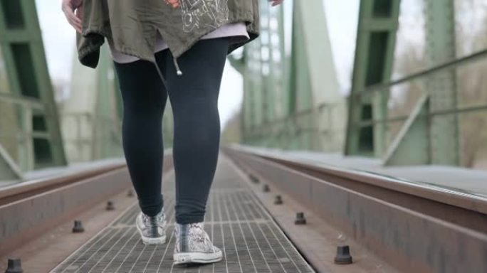 女人走在铁轨上脚部动作走动徒步出行出游