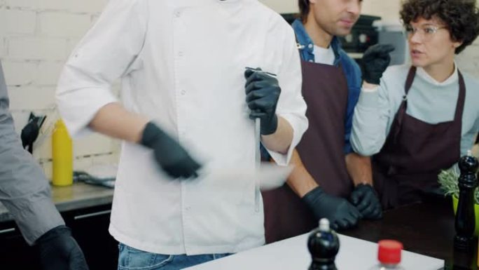 烹饪学校大师班期间，男厨师在厨房里磨刀刀