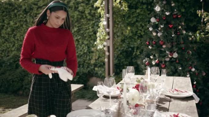 4k视频片段，一名年轻女子在家中摆放桌子，为圣诞节聚会做准备