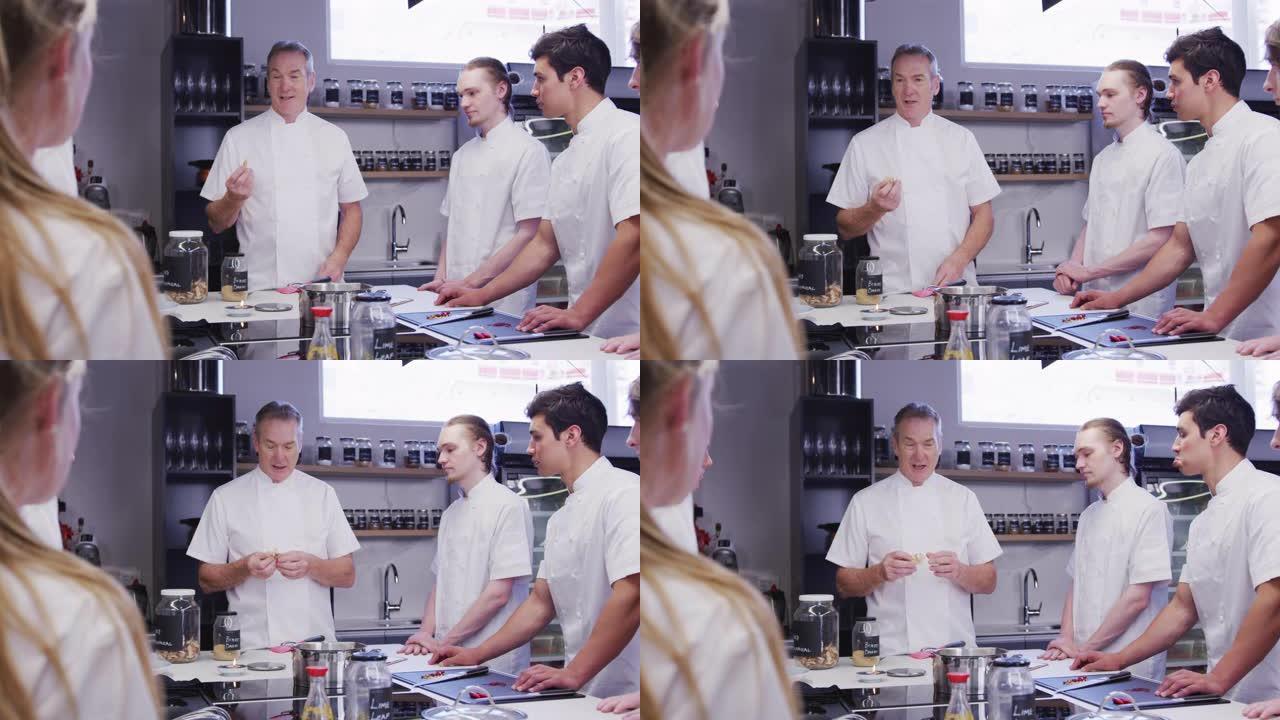 专业高加索男厨师在餐厅厨房教一群见习厨师