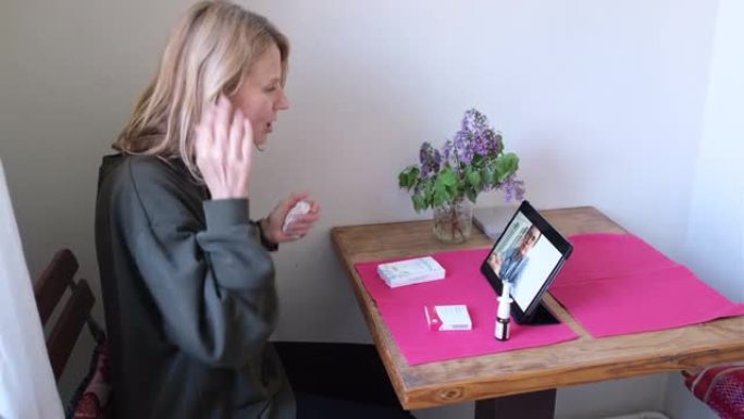 在家中的女性患者使用数字平板电脑与医生交谈