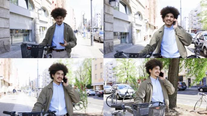 男人在城市里骑自行车走路时使用电话