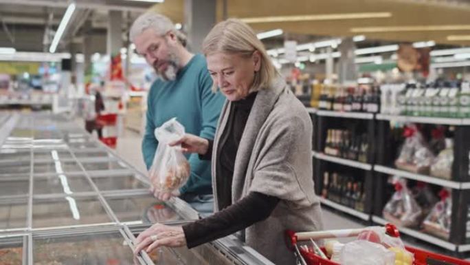 成熟的夫妇在超市购买冷冻混合蔬菜