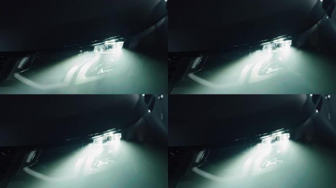 一辆黑色匿名豪华车前灯的美学特写。灯打开，揭示了现代著名汽车设计的细节。汽车广告与销售的概念