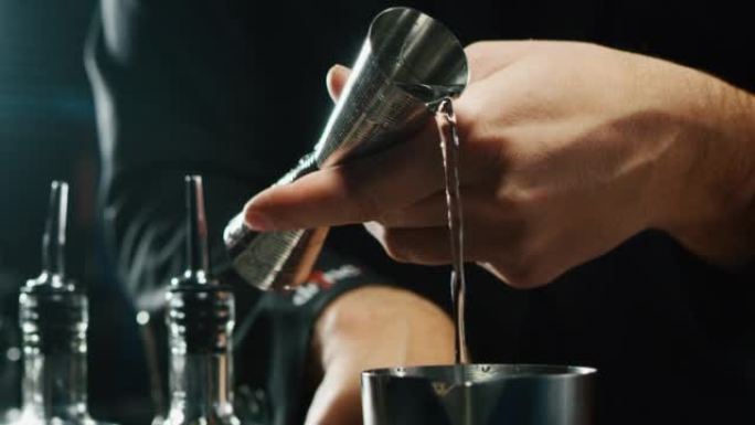 专业调酒师的特写镜头正在酒吧或迪斯科俱乐部为顾客准备含冰块的酒精鸡尾酒。