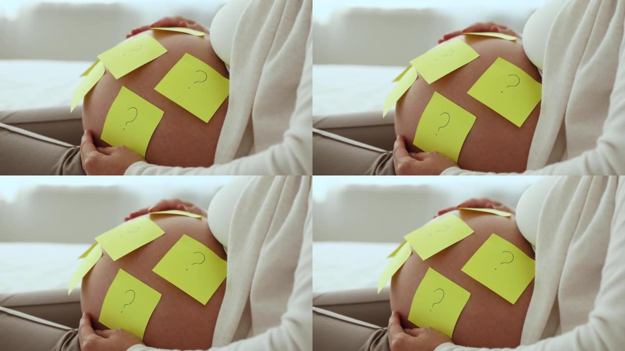 孕妇肚子上附有问题的便签