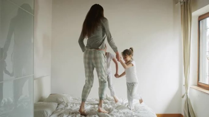 母亲和女儿在床上玩耍的真实镜头。